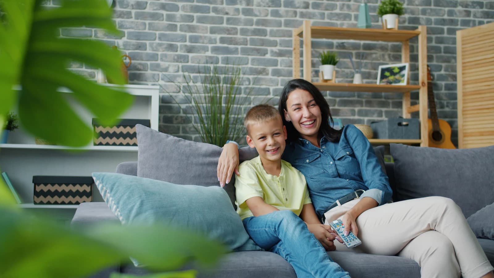 Eine Mutter und ihr Sohn entspannen auf dem Sofa in einem sauberen Wohnzimmer